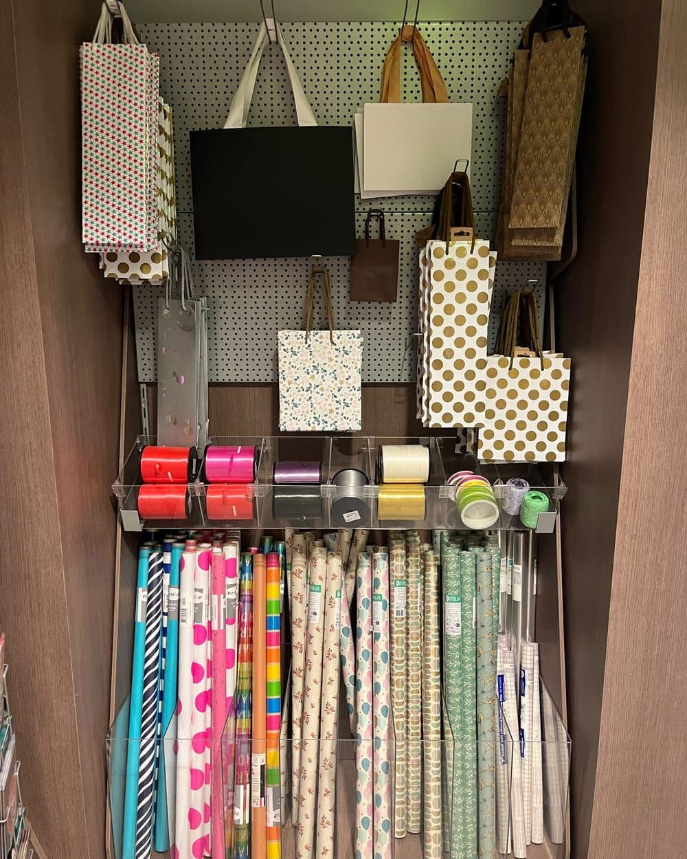 Rollen inpakpapier, linten en cadeautassen aan de muur