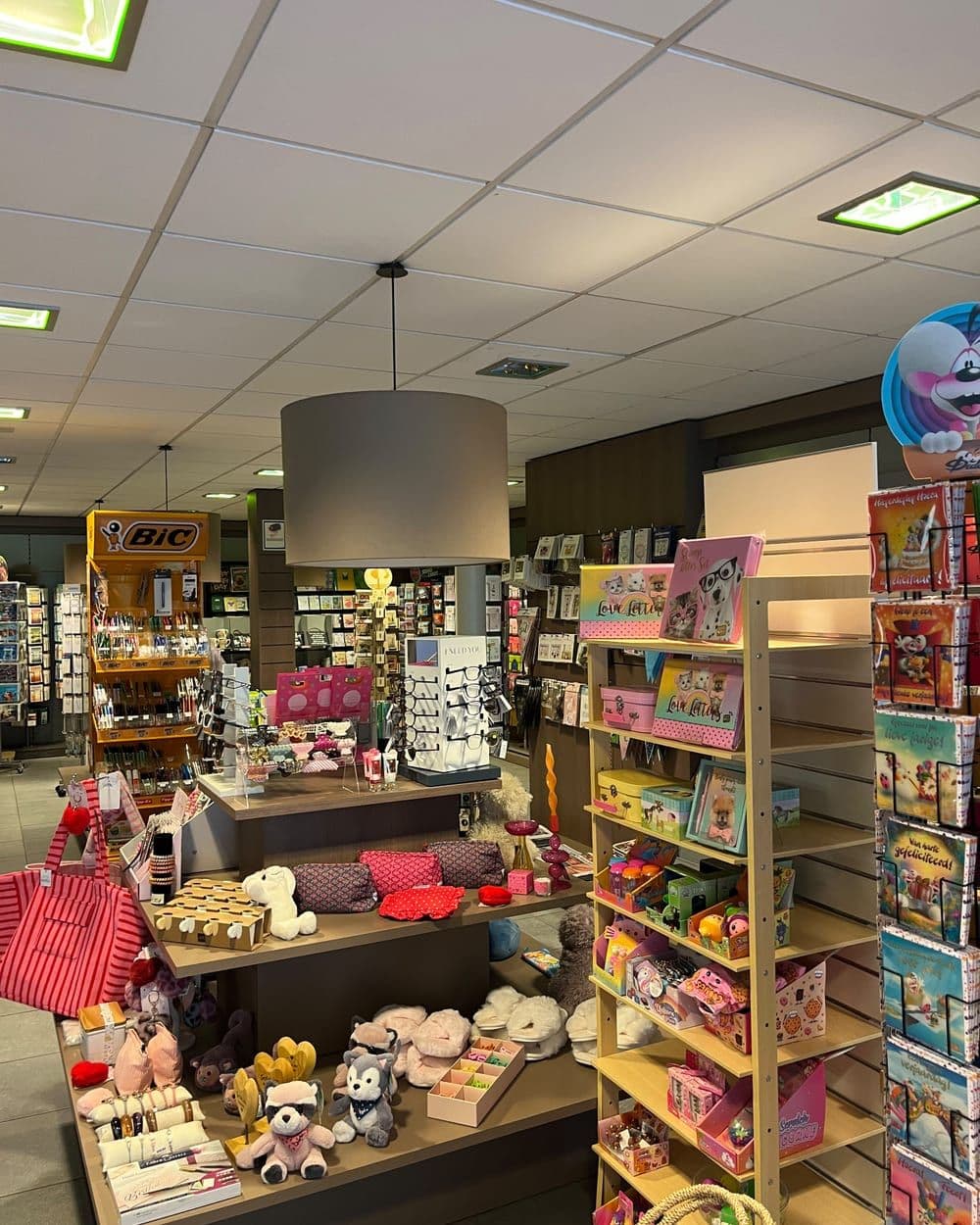 Zicht door de winkel, met schappen aan weerszijden